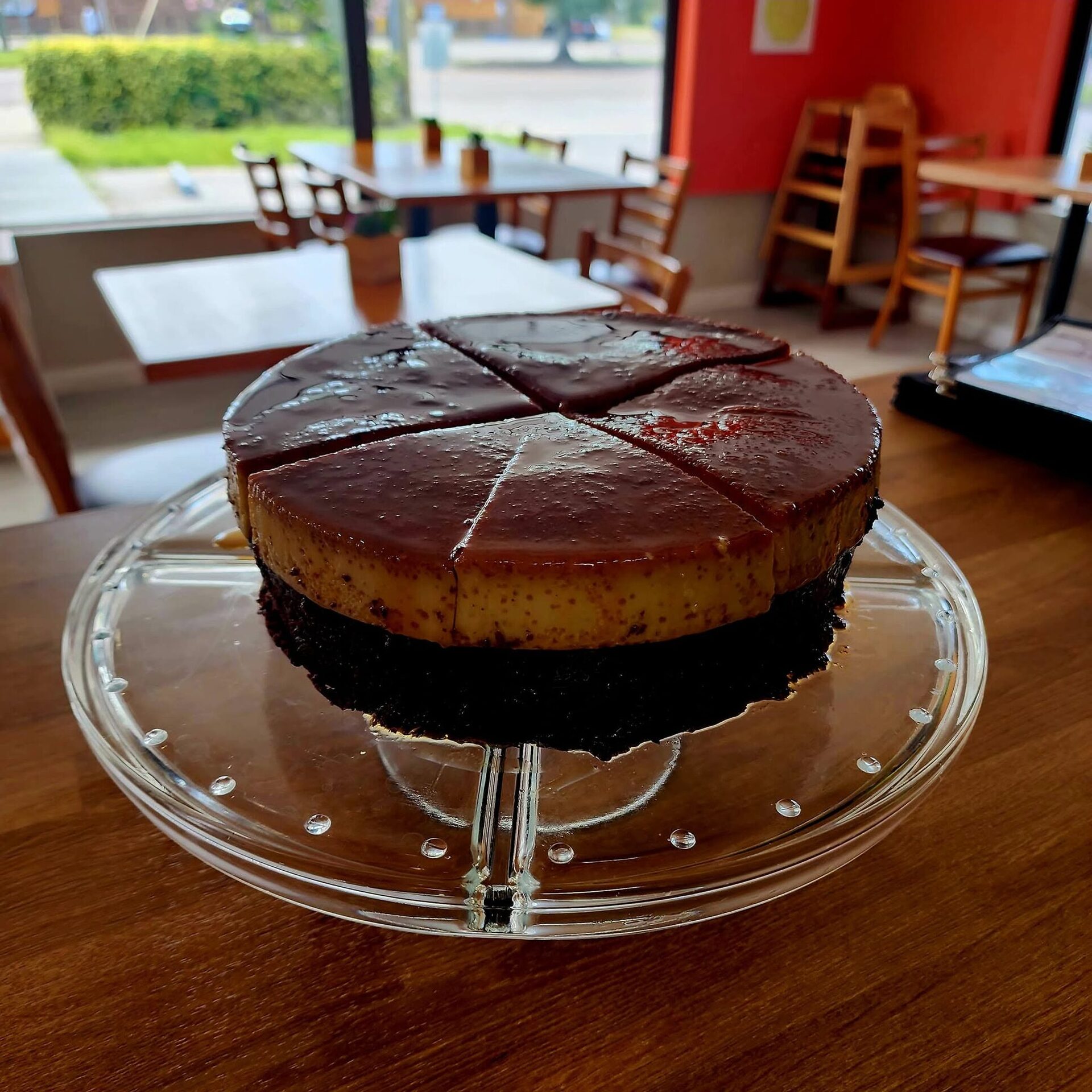 1Chick 1Bro: chocolate quesillo cake sliced on a glass stand in the dining room