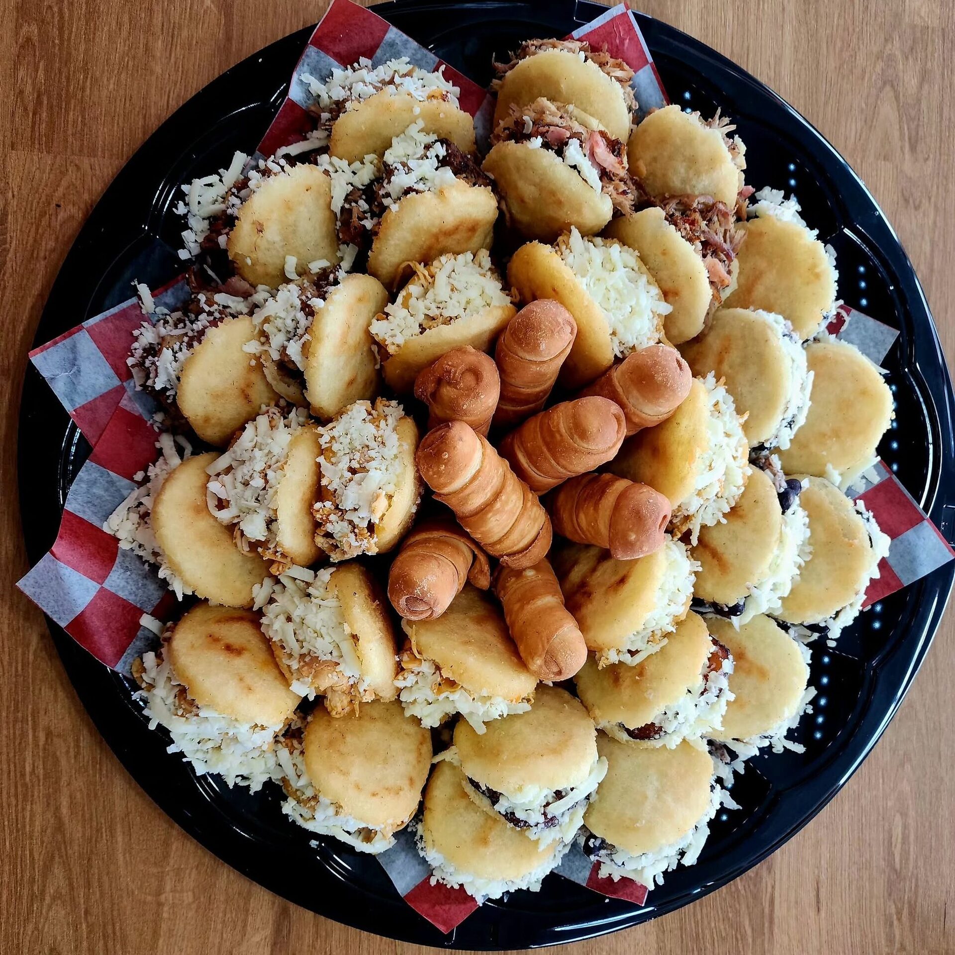 Overhead view of a 1Chick 1Bro platter of mini arepas with tequeños in the center